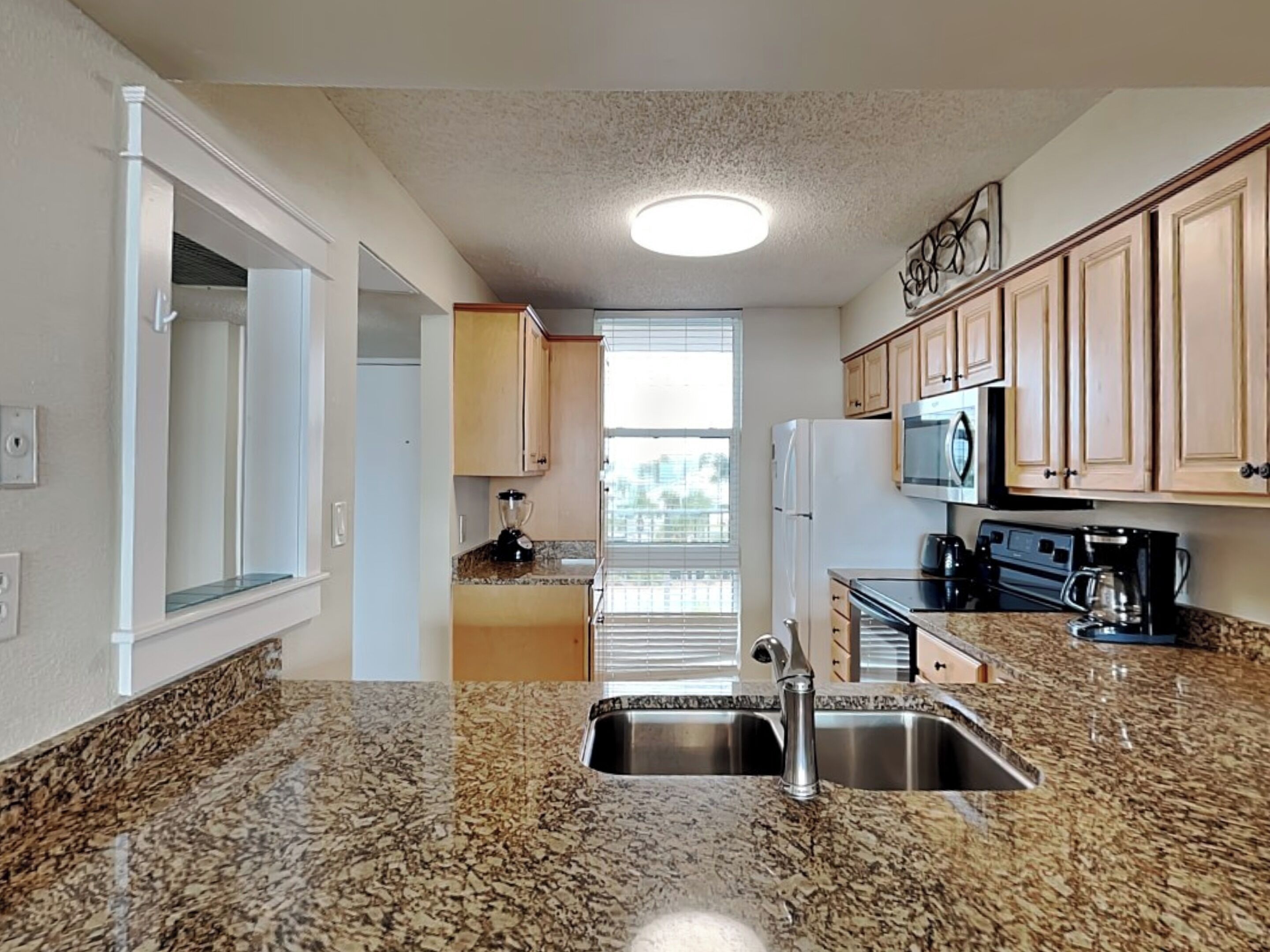 A kitchen with granite countertops, stainless steel appliances, and wooden cabinets.