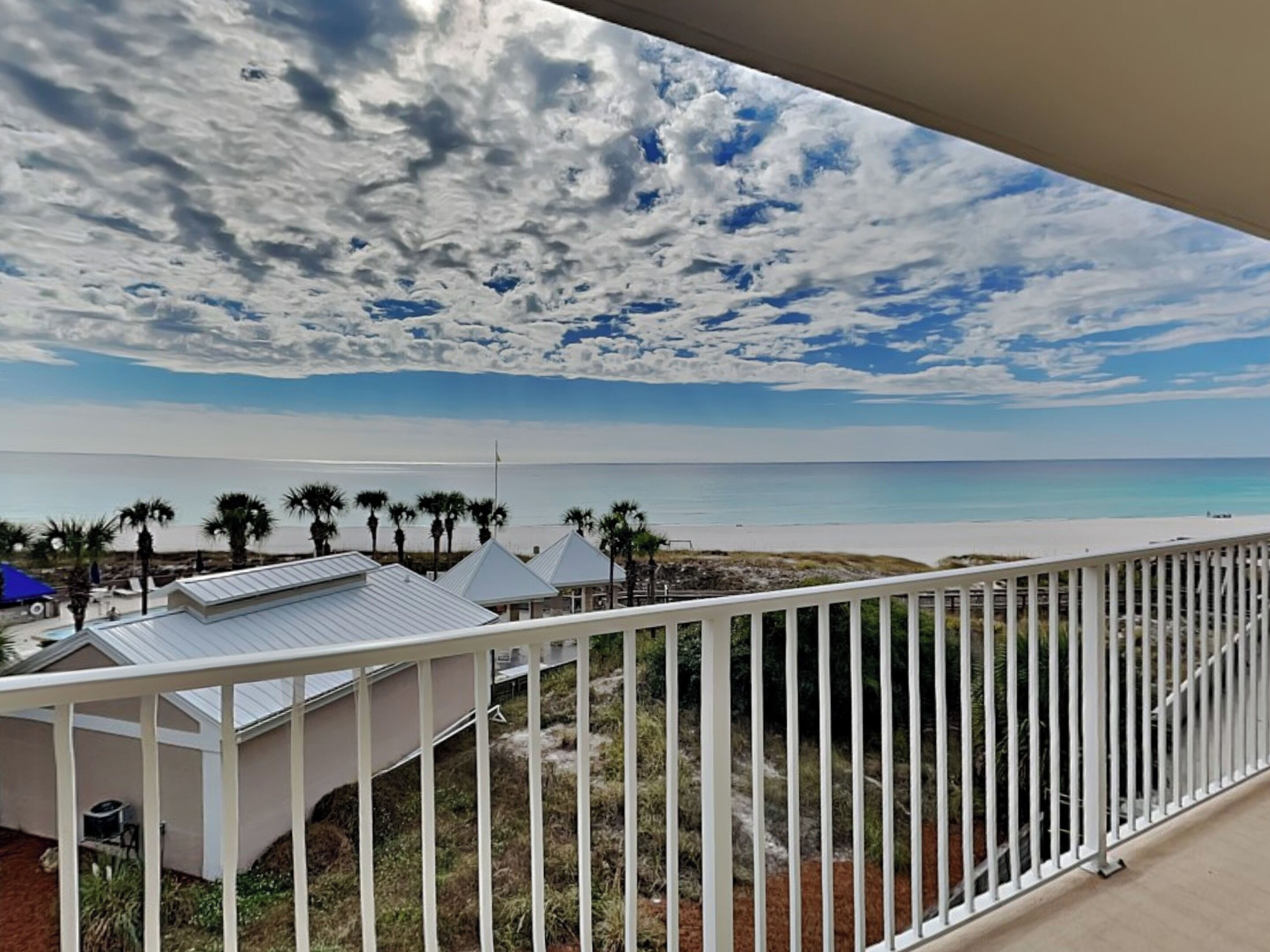 A balcony with a view of a beach and ocean.