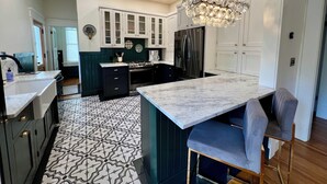 A modern kitchen with a central island, dark cabinetry, and a patterned floor.