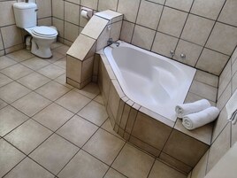Un baño con bañera, inodoro y perchero.