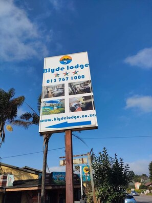 A billboard for Blydelodge with contact information and a website URL. - Blyde lodge (Graskop)