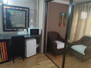 Um espaço compacto com cozinha compacta, área de jantar e sala de estar com sofá e poltrona.
