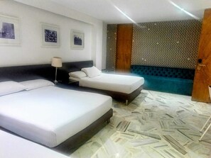 A hotel room with two beds, a nightstand, a lamp, a patterned wall, and a blue accent wall. - HOTEL KING VERSALLES (Cali)