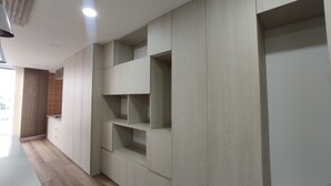 A modern interior with built-in shelving units and a wooden floor. - Modelia Living & Parking (Bogotá)