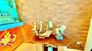 Een modelboot op een houten tafel voor een bakstenen muur.