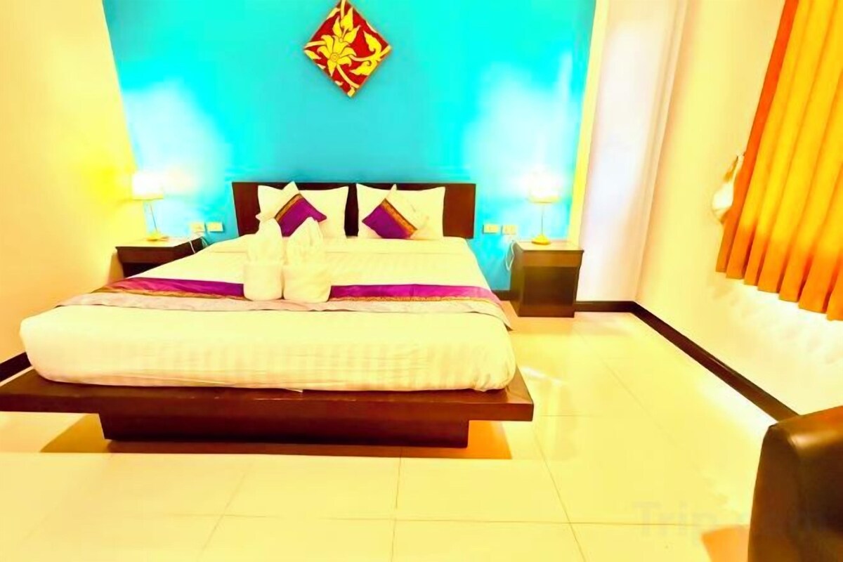 A hotel room with a bed, nightstands, and a wall-mounted light fixture.