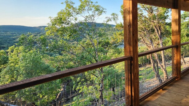 A wooden deck with a metal railing overlooking a forested landscape. - Stunning Views & Heated Cowboy Pool 5 min to River (Canyon Lake)