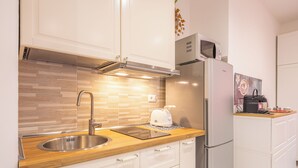 A modern kitchen with a stainless steel sink, a built-in microwave, and a refrigerator. - Cozy Flat near Vatican and Metro Station (Roma)