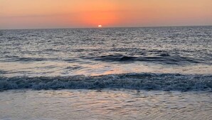 Tramonto sull'oceano con le onde che si infrangono sulla riva.