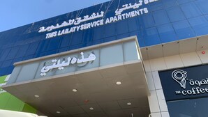 Un edificio con un letrero que dice "Lailatyservice Apartments" y una cafetería llamada "The Coffee".