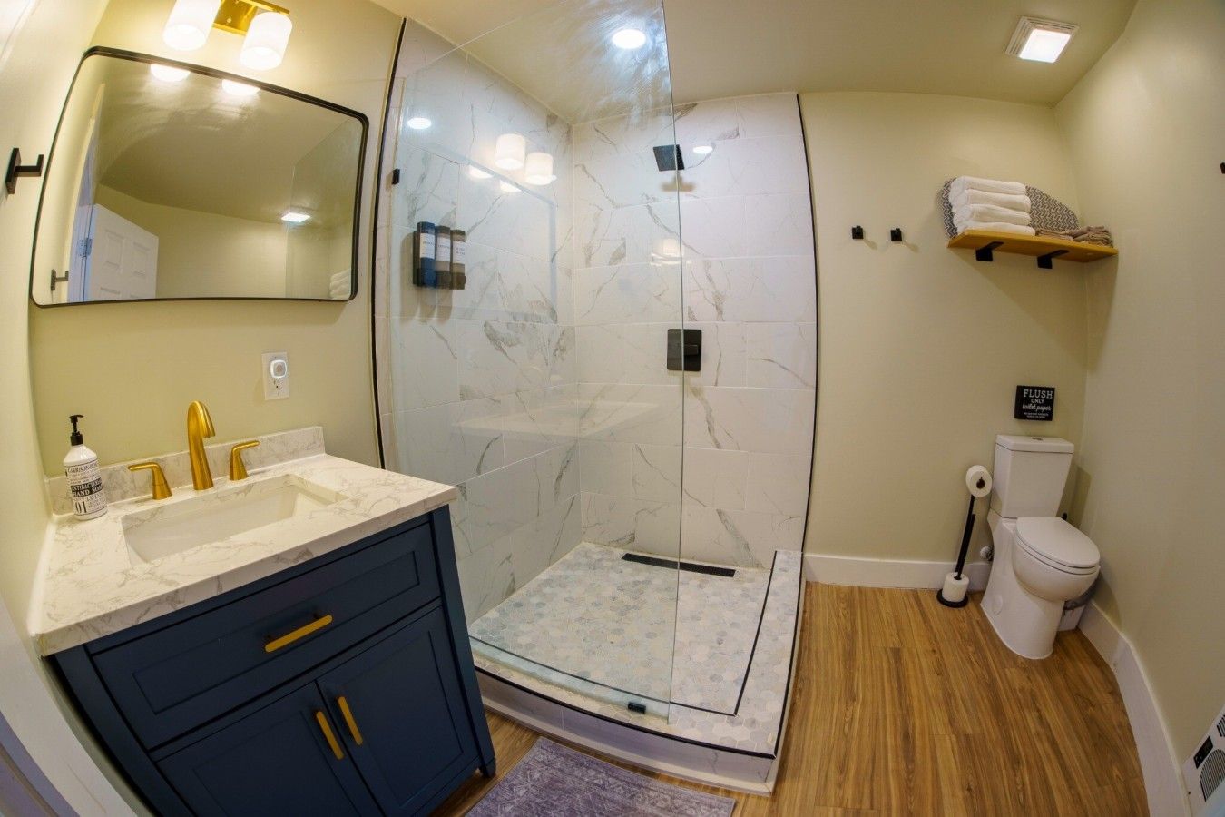 Une salle de bain avec douche, toilettes et lavabo.