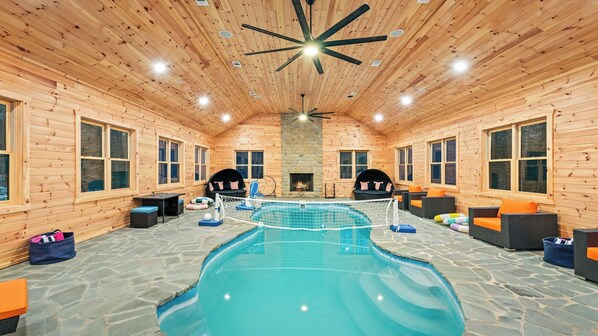 A wooden cabin with a swimming pool, stone flooring, and a fireplace. - Grand Timber by Avantstay Indoor Pool + Sports Court + Game Room & More! (White Haven)