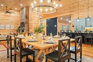 Interior de madera con comedor, pared de piedra y un gran barnizo.