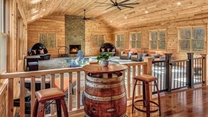 A wooden cabin interior with a hot tub, seating area, and a fireplace. - Grand Timber by Avantstay Indoor Pool + Sports Court + Game Room & More! (White Haven)