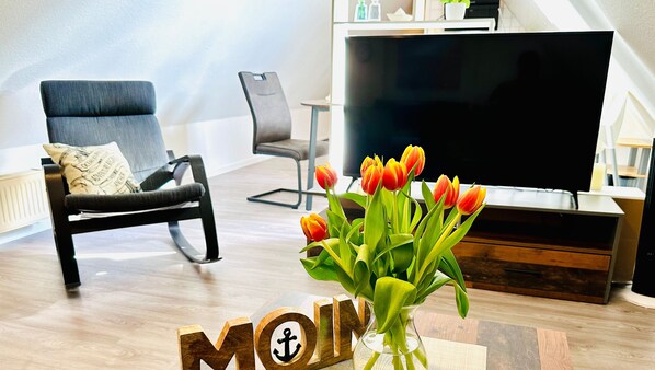 Relax in a cozy seating area with a sofa, armchair, and flat-screen TV.