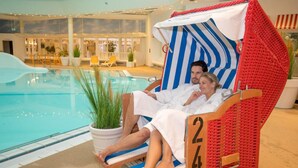 Ein Poolbereich mit einer Liege mit der Nummer 240, einem Pool und Sitzgelegenheiten mit Pflanzen.