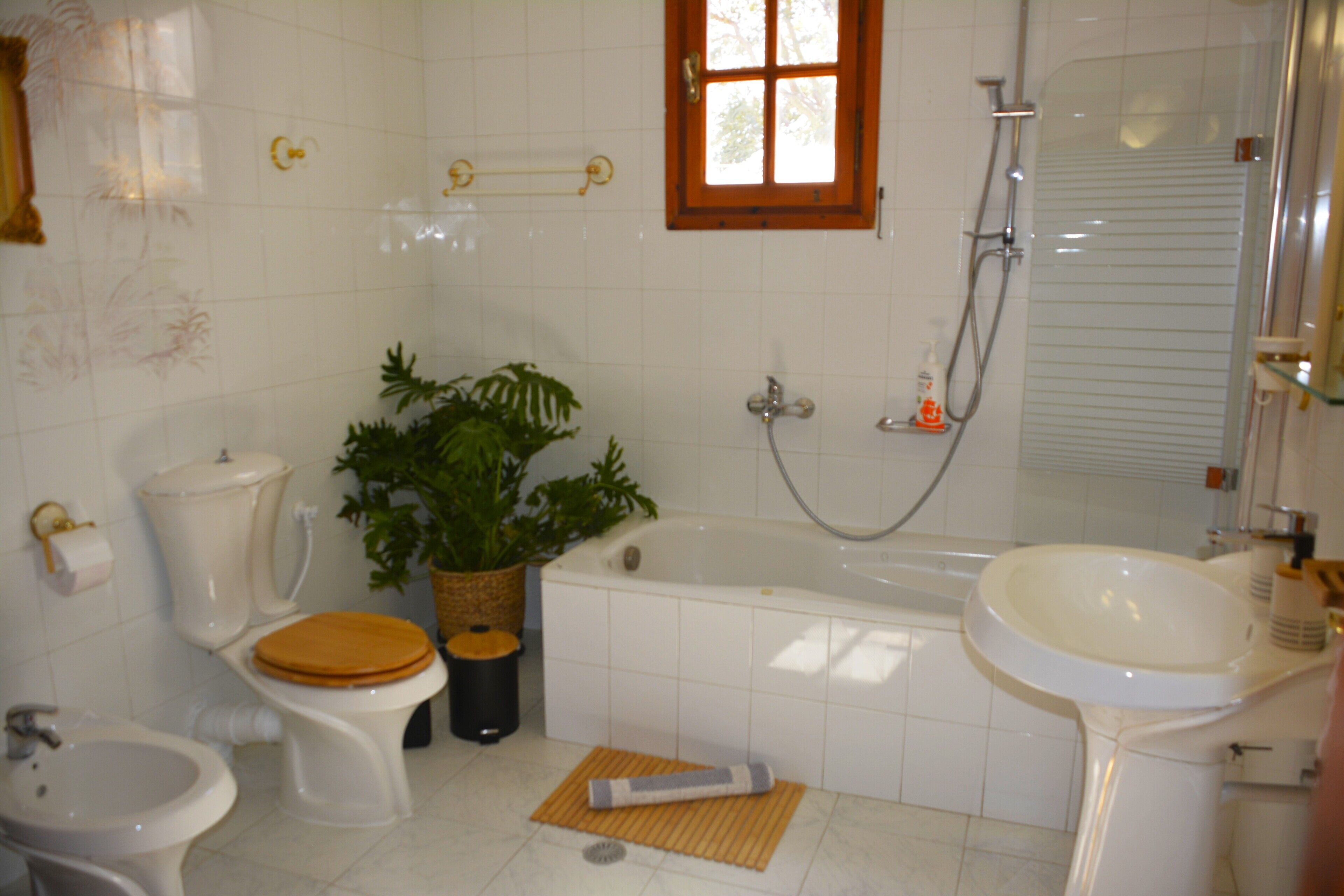 A bathroom with a toilet, bidet, bathtub, and sink.