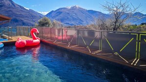 A swimming pool with a wooden deck and a red inflatable flamingo. - VILLA DEI VENTI-BREVA by Curti rentals (Calozzo)