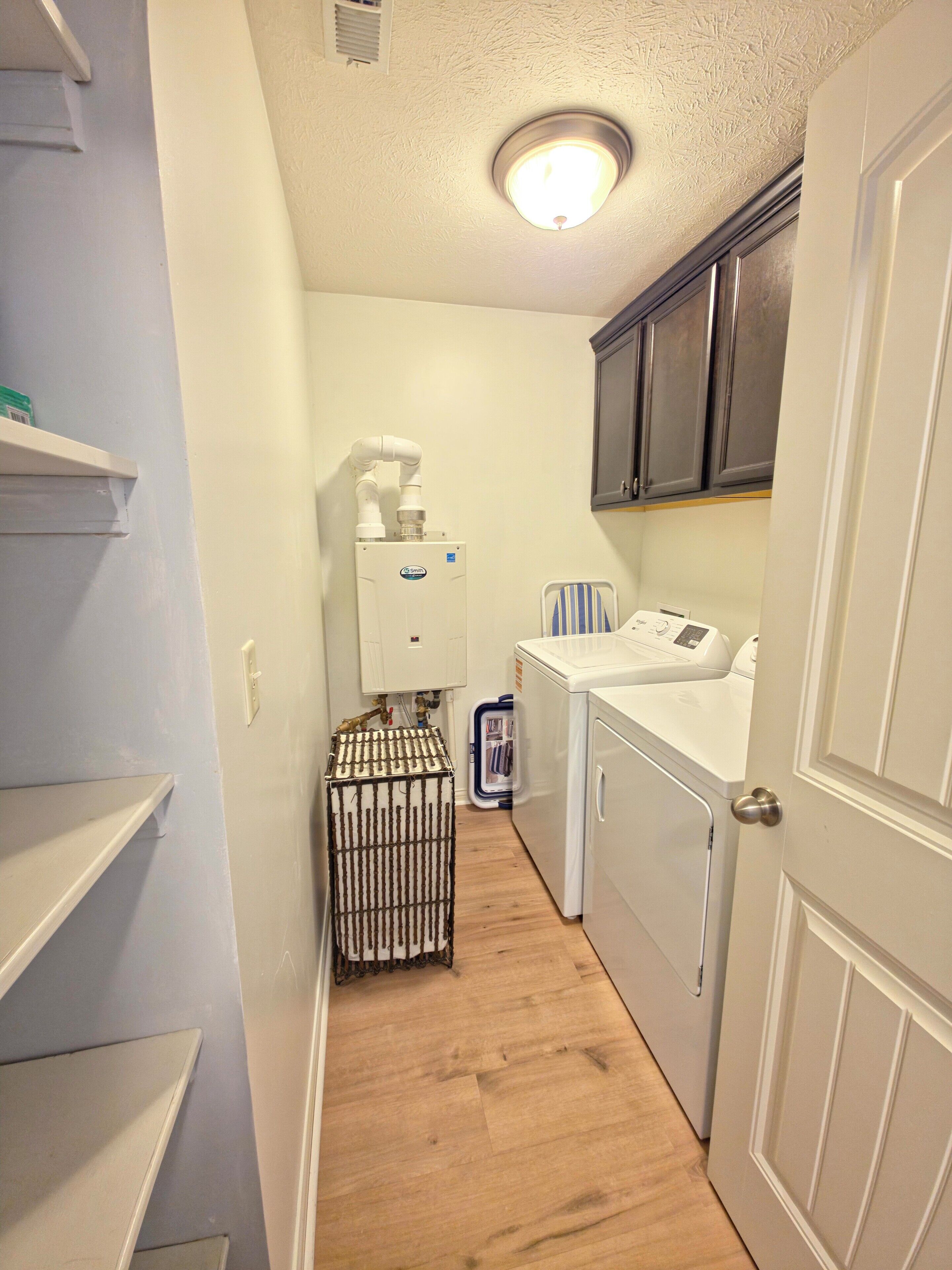 A laundry room with a washing machine, dryer, and stacked laundry baskets.