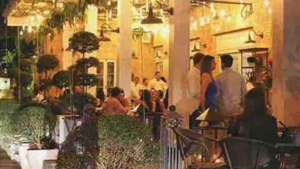 Un espace de restauration intérieur agrémenté de plantes suspendues et d’un éclairage chaleureux.