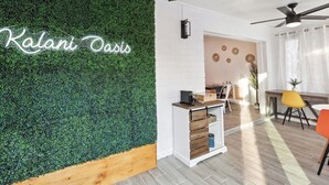 Un espace d’accueil agrémenté d’un mur végétal, d’un bureau en bois et d’un ventilateur de plafond moderne.