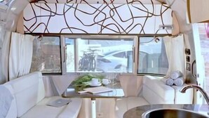 A compact kitchenette with a sink, a small table, and a window providing a view of the outside. - Cool California Coast Airstream (Half Moon Bay)