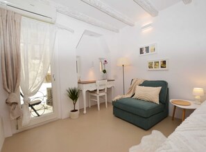 Relax in this serene bedroom with a comfortable sofa bed, desk, and large mirror.