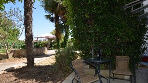 An outdoor patio with two wicker chairs, a table, and a bottle of wine. - Tranquil Rovinj Studio Apartments - Studio Apartment with Terrace (Rovinj)
