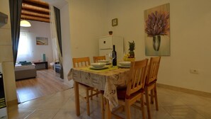 A dining area with a table set for four, a refrigerator, and a painting on the wall. - Tranquil Rovinj Studio Apartments - Studio Apartment with Terrace (Rovinj)