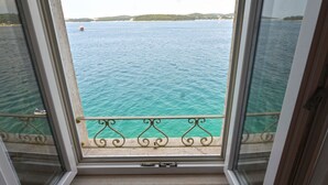 A view from a window with a metal balustrade, overlooking a body of water with a distant shoreline. - Serene Sea View Rovinj Apartment - Two Bedroom Apartment with Sea View (Rovinj)