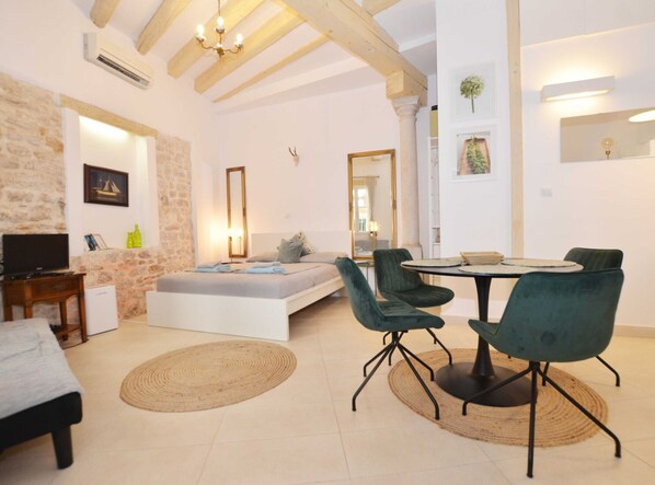Relax in a stylish living space with a sofa, TV, and dining area.
