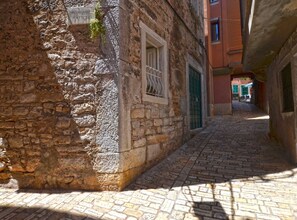 Stroll along Poloz Passo Nattori, lined with historic buildings featuring traditional architecture.