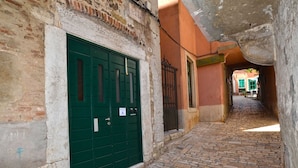 A narrow cobblestone street with a green door and a metal gate, leading to a building with a sign that reads "Motel Bistra". - Modern and Cozy Rovinj Old Town Apartments - Classic Studio Apartment (Rovinj)