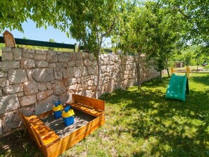 Enjoy a family-friendly outdoor play area with a wooden play structure and lush greenery.