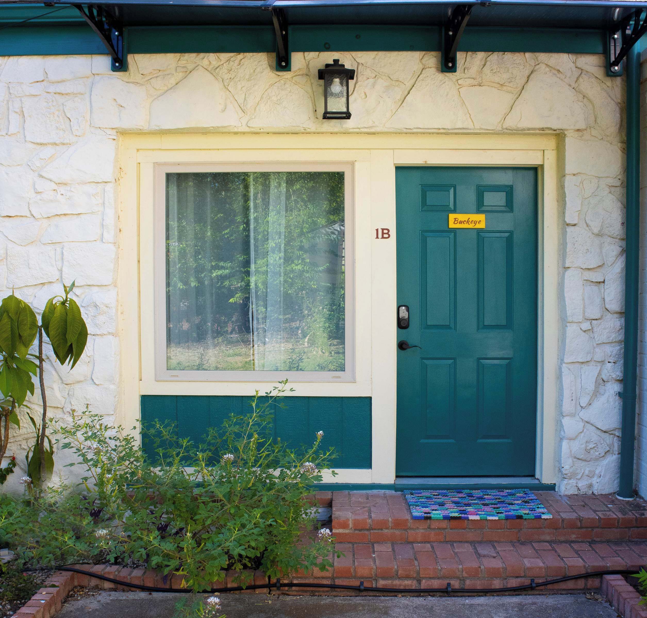 Uma casa com porta verde, janela e caixa de correio.