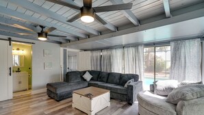 Un salón amplio con un sofá modular, una mesa de centro y un ventilador de techo.