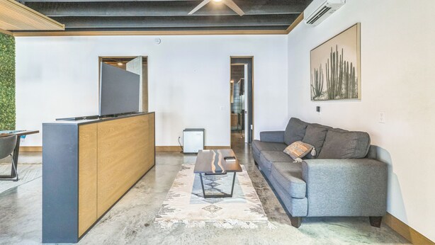 Een moderne woonkamer met een bank, salontafel en een televisie.