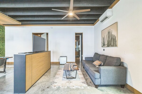 A modern living room with a sofa, coffee table, and a TV.