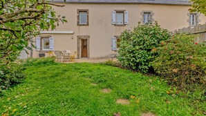 Uma casa de dois andares com um jardim na frente.