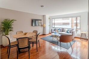 Relax in this stylish living space with a dining table, sofa, and flat-screen TV.