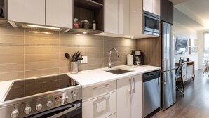 Eine moderne Küche mit Einbauofen, Edelstahlkühlschrank und Kaffeemaschine.