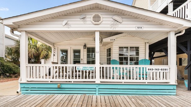 A beachfront building with a covered porch, numbered 1014, and a sign indicating golf cart parking. - Ocean Lakes Site 1014 3bed/2bath, Sleeps 8 Ocean View /Golf Cart (Myrtle Beach)