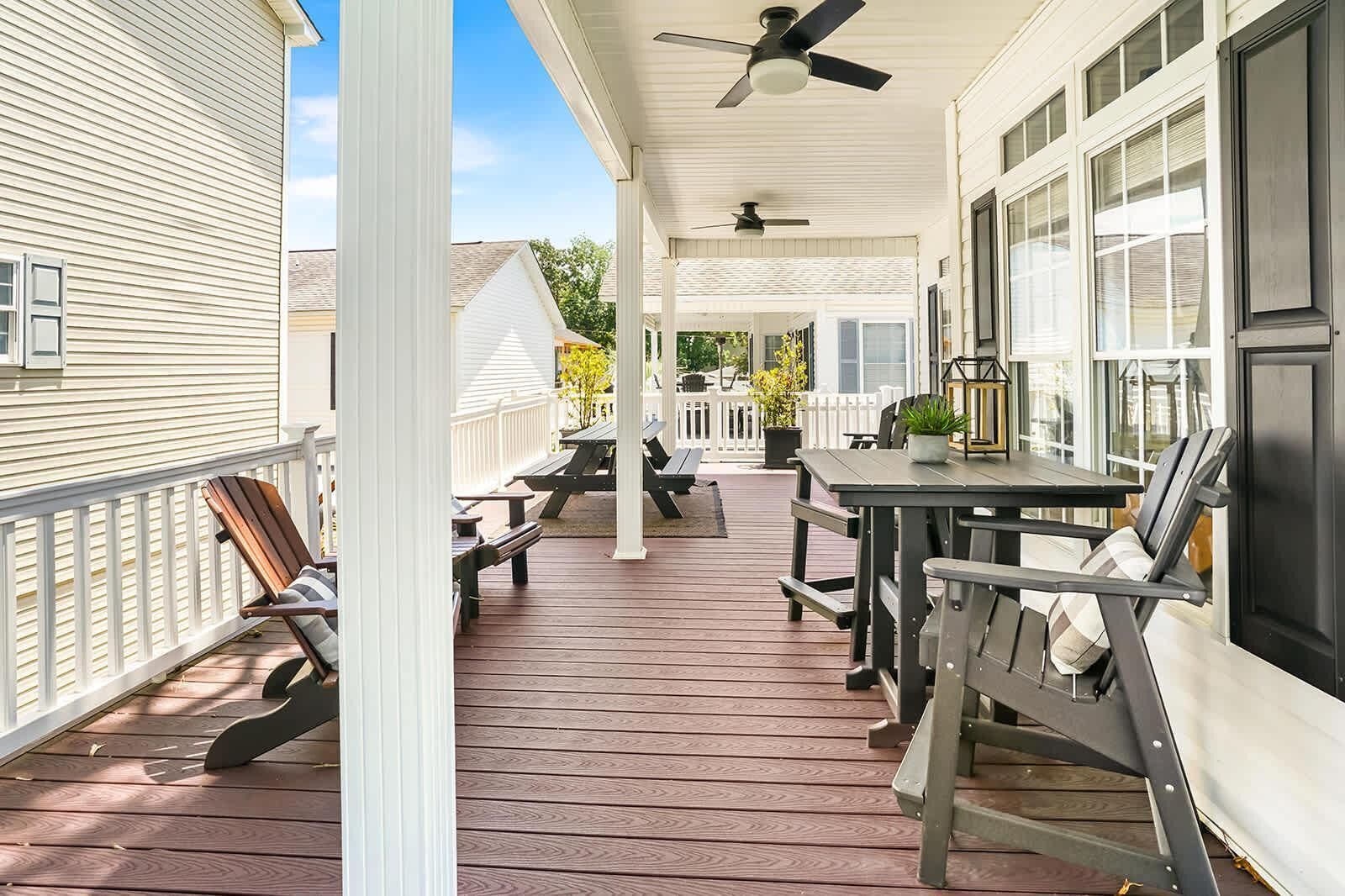 A covered porch with a table and chairs, a ceiling fan, and a view of the backyard.