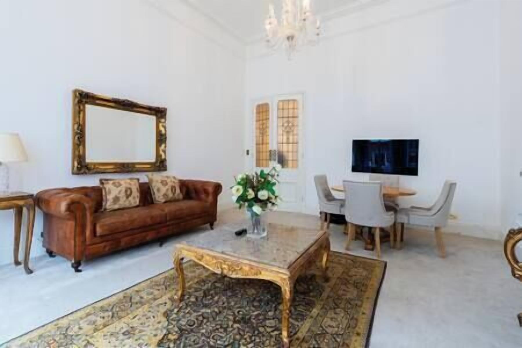 A living room with a brown sofa, a coffee table, a TV, and a dining area with chairs.