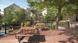 An outdoor deck with picnic tables and a pool in the background. - Experience Family Fun and Ozark Beauty at Wyndham Branson at The Meadows-2 Bd Dl (Branson)