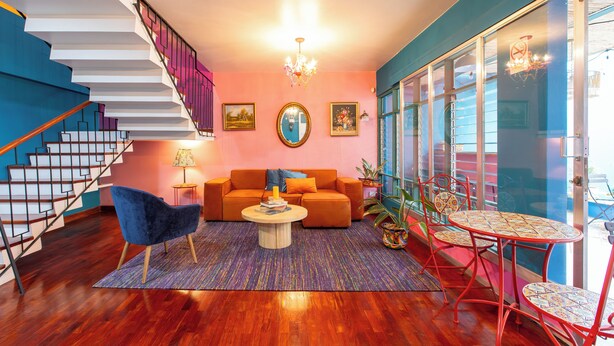 A modern living room with a staircase, a sofa, a coffee table, and a dining area with chairs. - Casa Zafiro B&B (San Pedro)