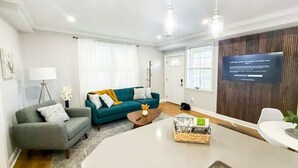 Un salon moderne avec un canapé, une table basse et un téléviseur fixé au mur.