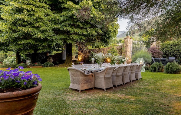 An outdoor dining area with wicker furniture and a stone pillar. - Awesome home in Capannori with WiFi (Capannori)
