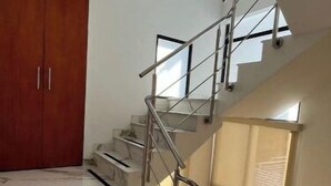 Una escalera con barandilla de vidrio y un armario de madera.