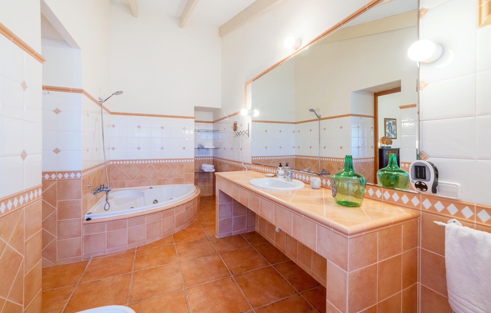 A bathroom with a bathtub, two sinks, a mirror, and a shower.